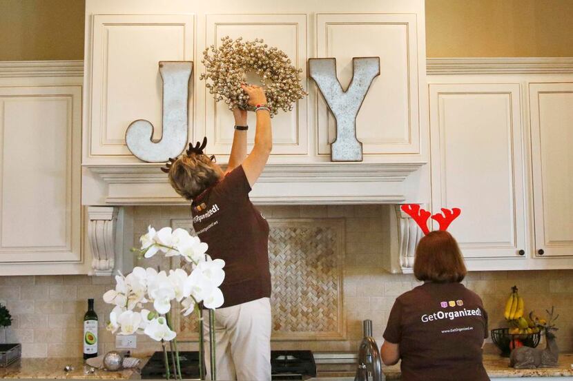 
Karla Koehler climbs high to place a wreath in just the right place in the kitchen of...