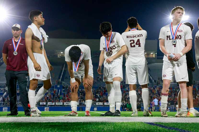 Plano players hang their heads after receiving their Class 6A boys soccer state runner-up...