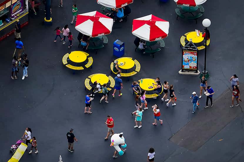 Park visitors walk near a food concession at Six Flags Over Texas on Thursday, March 12,...