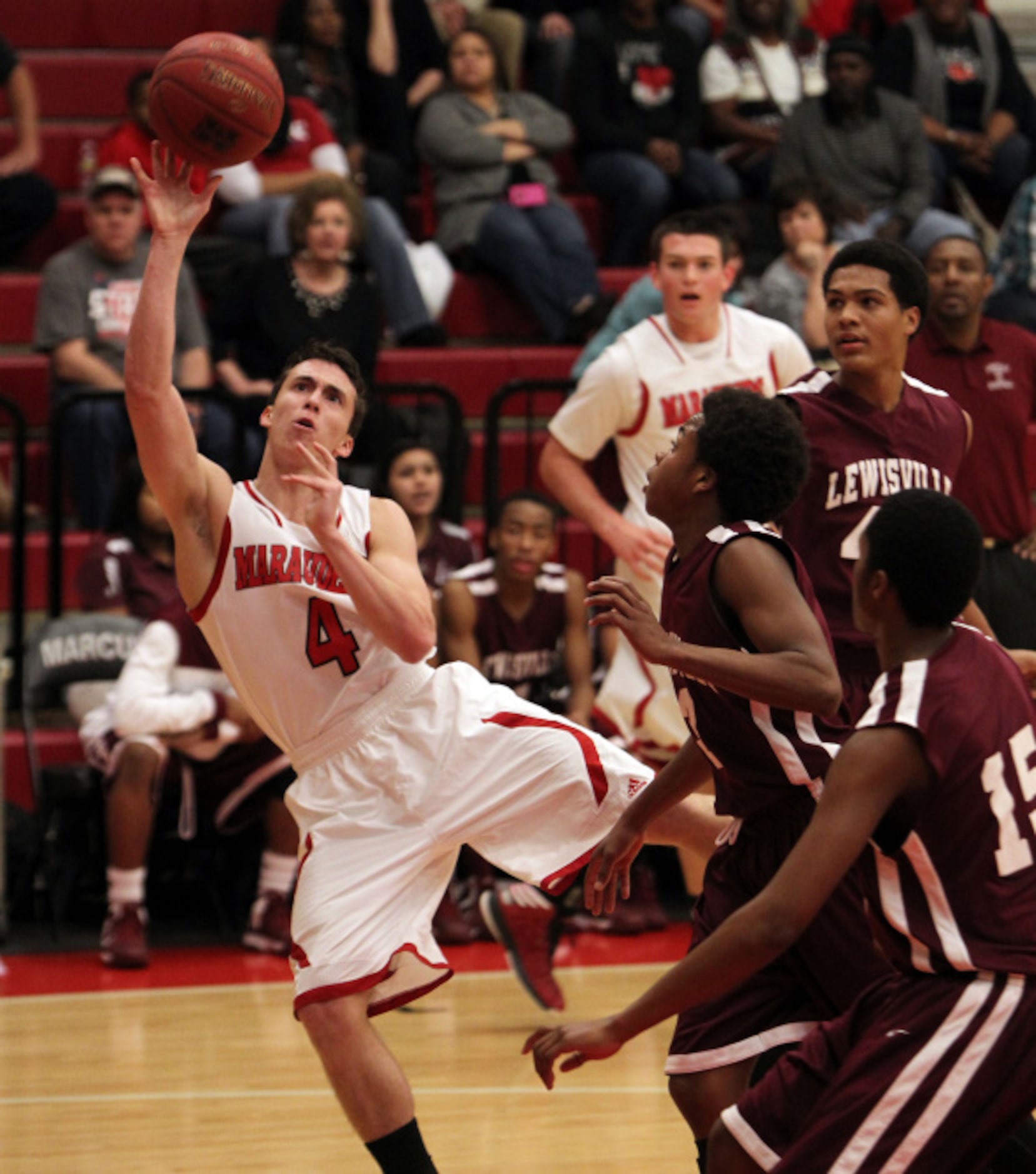 Marcus Marauders guard Aaron Steele (4) makes a shot around Lewisville Fighting Farmers...