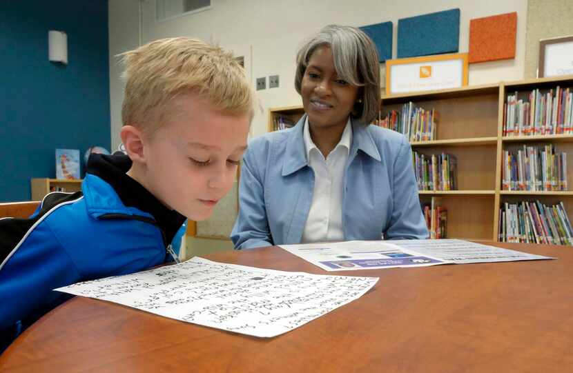 BARRETT GIBBINS , 7, interviews Withers Elementary principal Connie Wallace in the school’s...