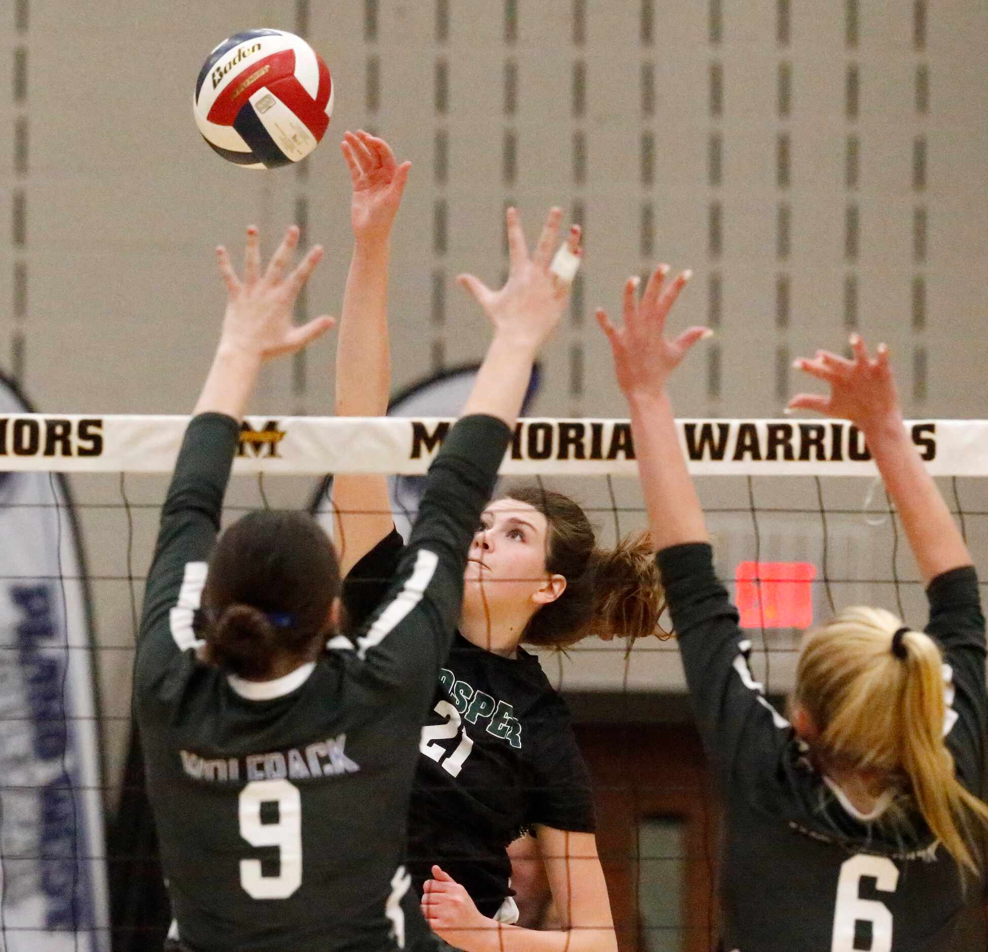 Prosper High School outside hitter Ayden Ames (21) hits past Plano West High School middle...