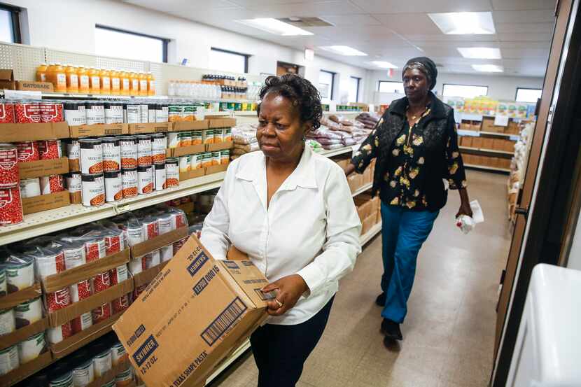 Betty Rayson, left, and Gladys Coleman stock food pantry shelves at Harmony Community...