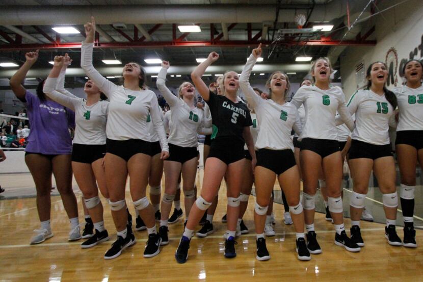 Members of the Southlake Carroll volleyball team revel in the moment after defeating...
