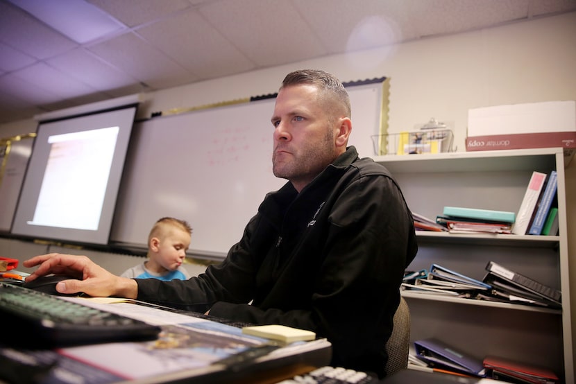 Plano East High School mathematics teacher Gary Don Moore uses the computer as his son Trey...