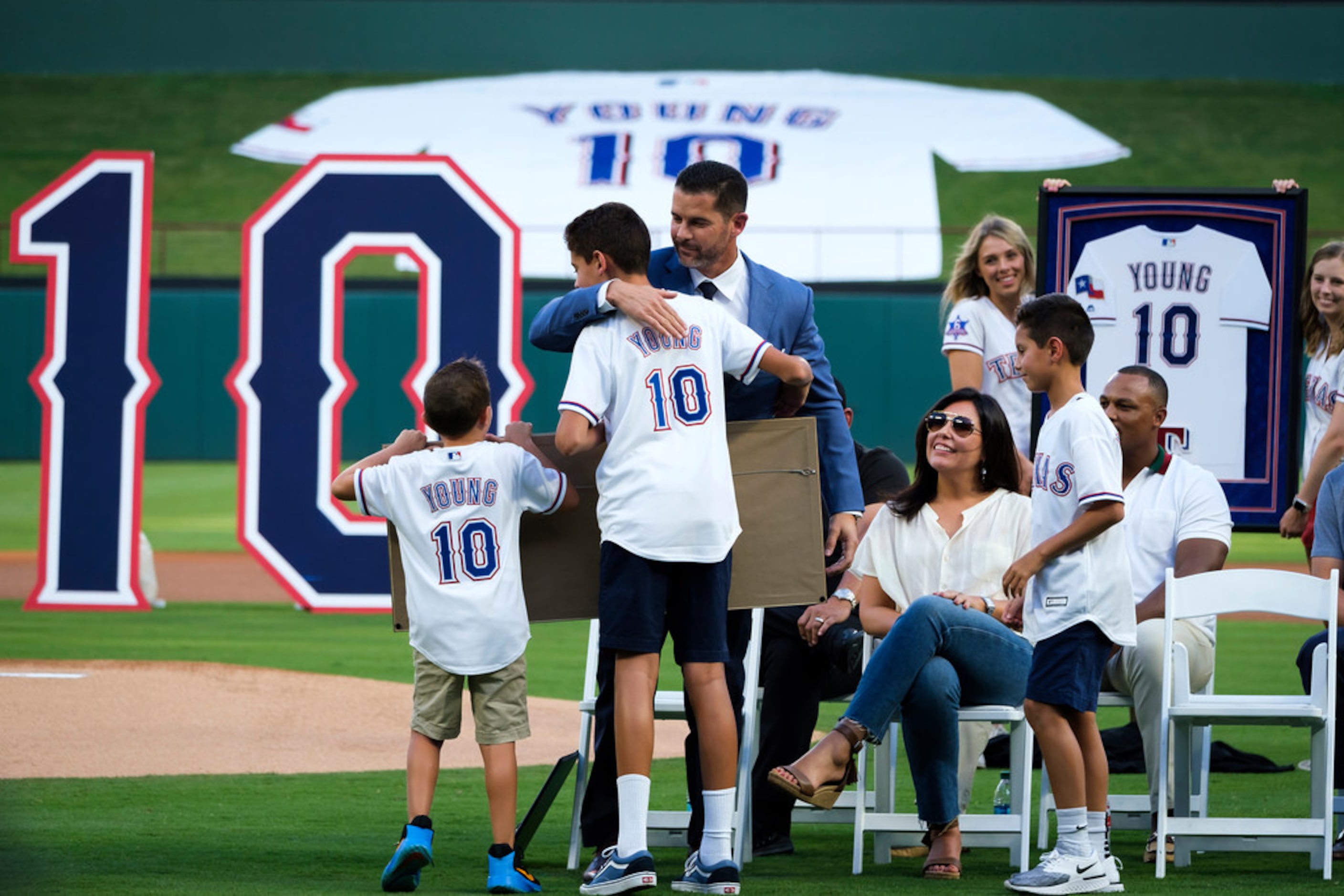 Michael Young hugs his son Mateo,14, during ceremonies to retire Young's No. 10 before a...