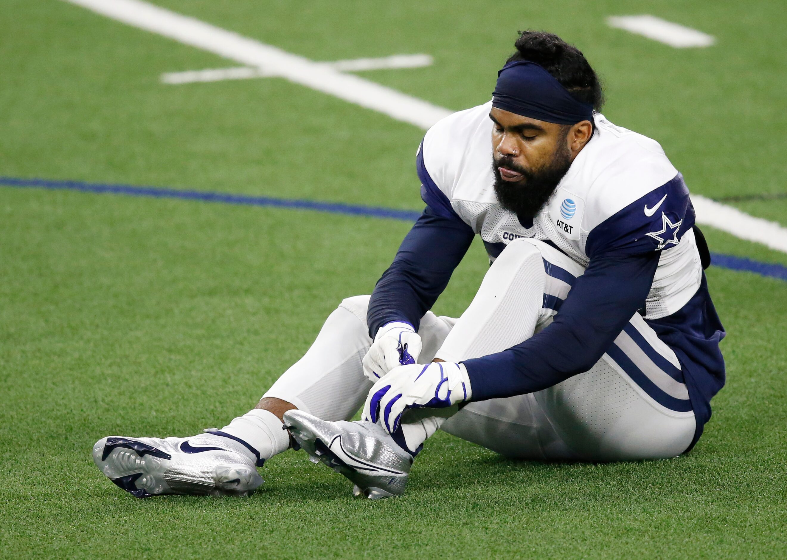 Dallas Cowboys running back Ezekiel Elliott (21) puts on his shoe in practice during...