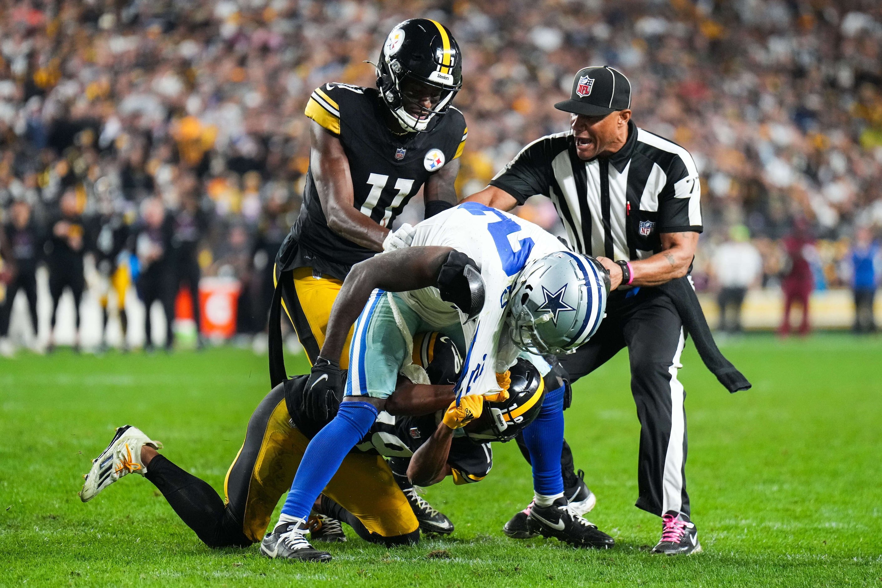 Umpire Terry Killens (77) rushes in to separate Dallas Cowboys cornerback Jourdan Lewis (2)...