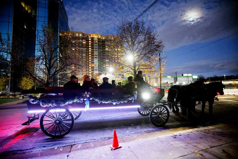 People ride a horse carriage from NorthStar Carriages, Sunday, Dec. 24, 2023, in Highland...