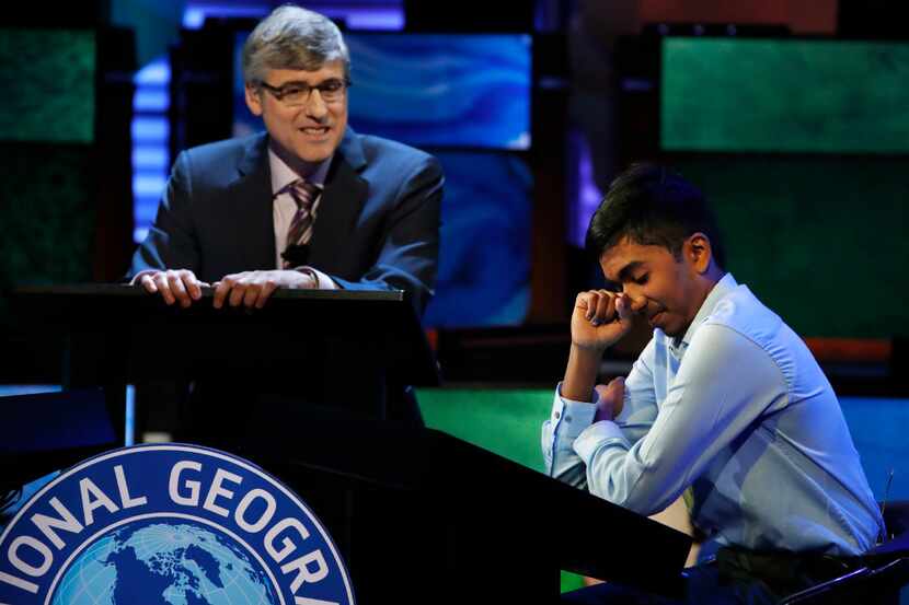 Host Mo Rocca watches at left as Pranay Varada, 14, of Carrollton, Texas reacts after...