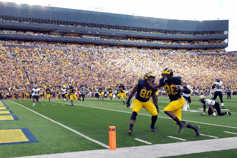 Michigan fullback Khalid Hill (80) cheers on wide receiver Jehu Chesson (86) as he scores a...