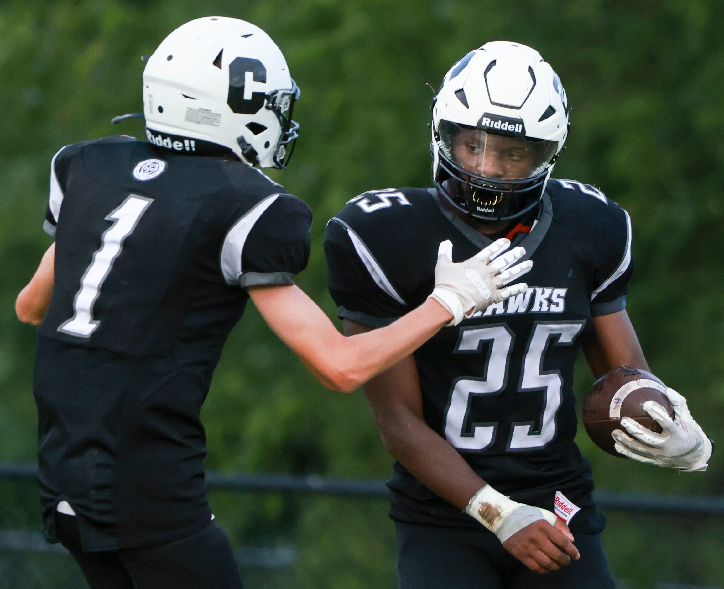 Cistercian Preparatory School Mac Schneider (1) celebrates with Nonso Unini (25) as he...