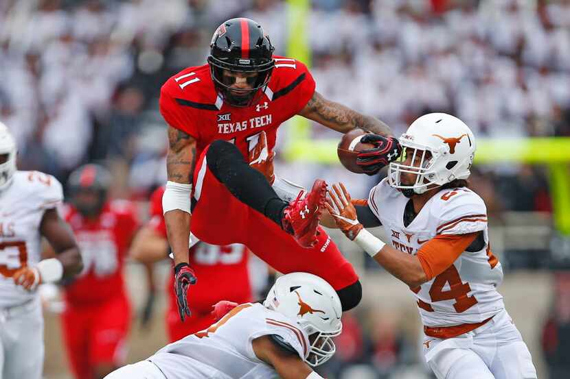 Texas Tech's Derrick Willies (11) jumps over Texas' Jason Hall (31) and around John Bonney...