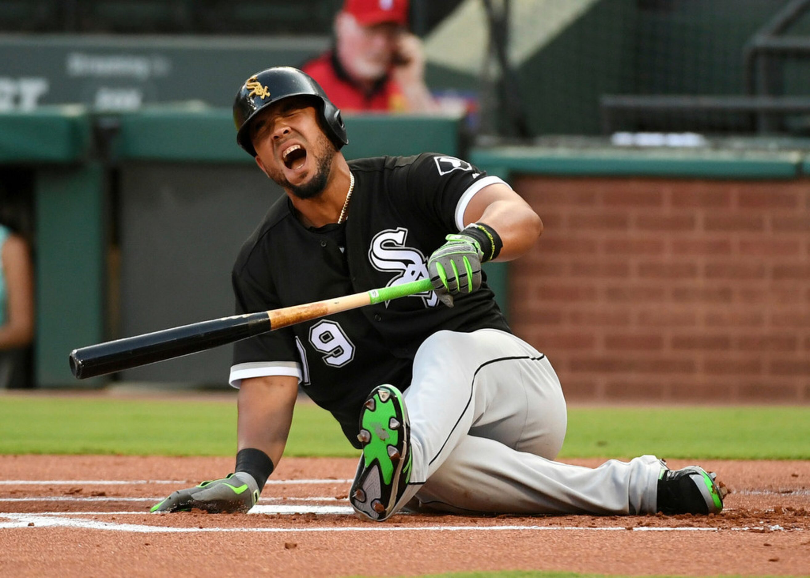 Chicago White Sox's Jose Abreu falls to the ground in pain after fouling a pitch from Texas...