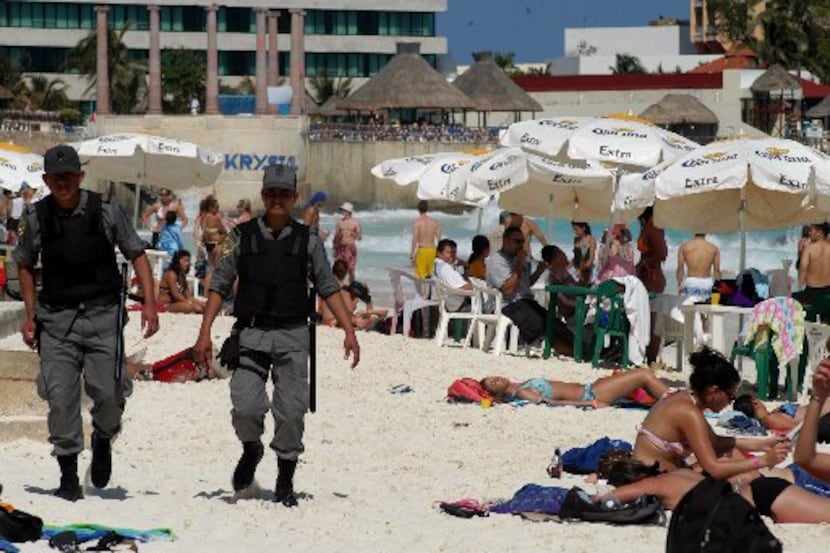 Police patrol the beaches of Cancun, Mexico, during the spring break tourist season.