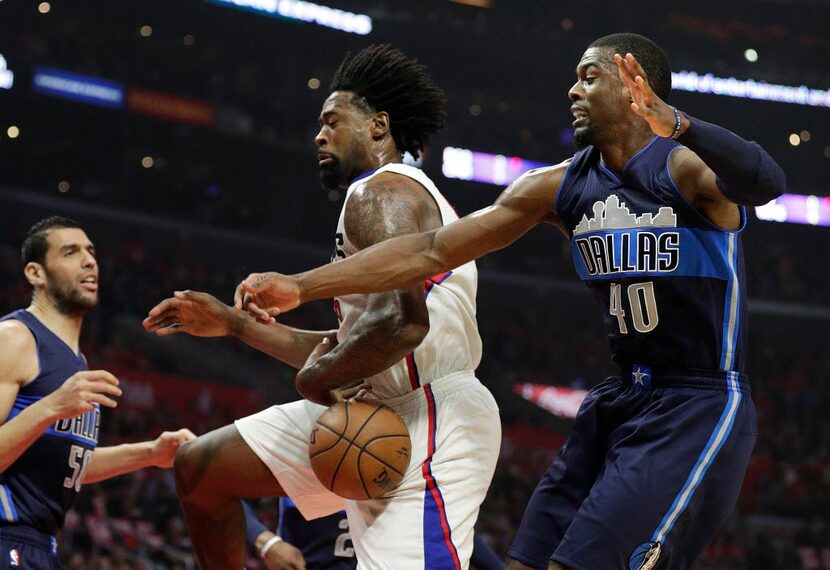 Los angeles Clippers' DeAndre Jordan, center, is defended by Dallas Mavericks' Harrison...