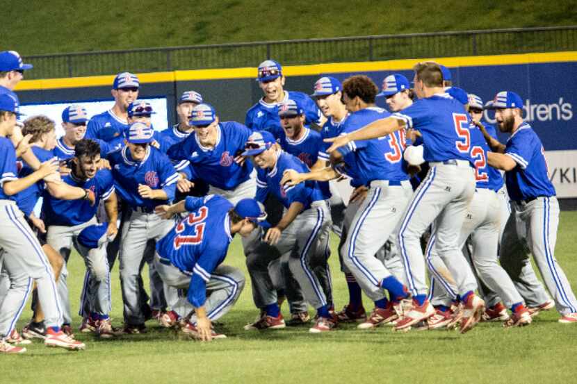 Grapevine teammates celebrate as outfielder senior Dylan Gonzales slides into the group...