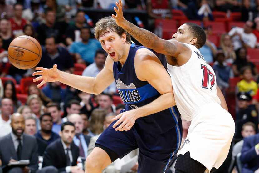 Dallas Mavericks forward Dirk Nowitzki, left, of Germany, loses control of the ball as he...