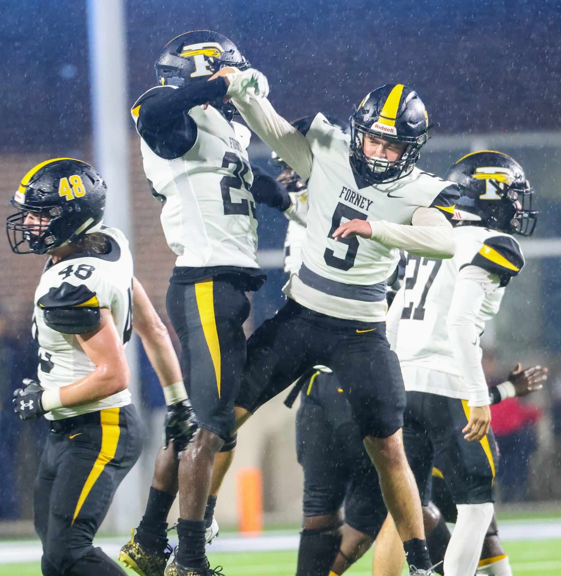 Forney defensive back Jaden Wise (27) and line backer Easton McMillan (5) run and jump at...