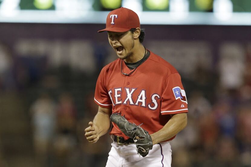 Texas Rangers starting pitcher Yu Darvish, of Japan, reacts after throwing the final strike...