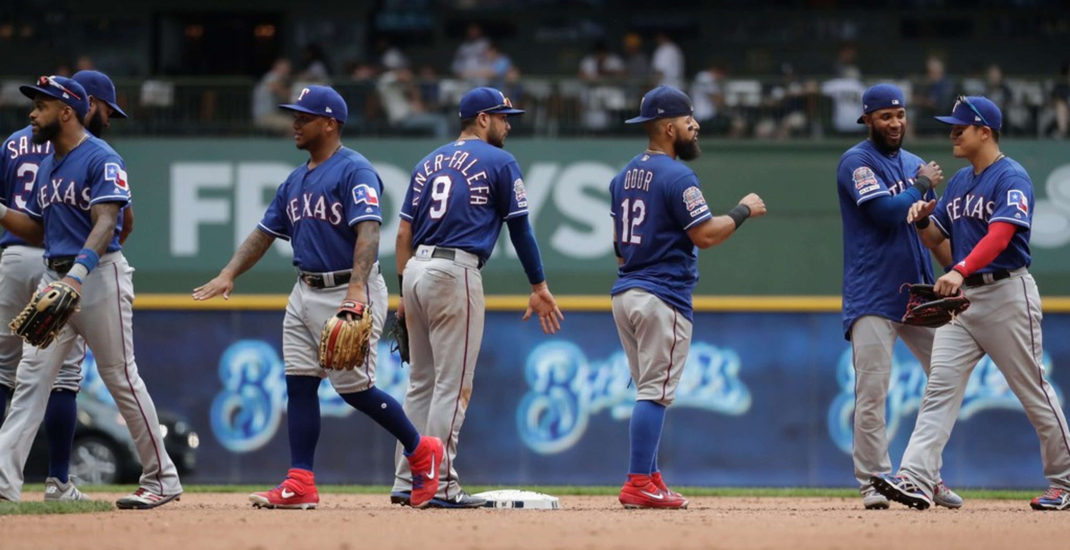 The Texas Rangers celebrate after a baseball game against the Milwaukee Brewers Sunday, Aug....