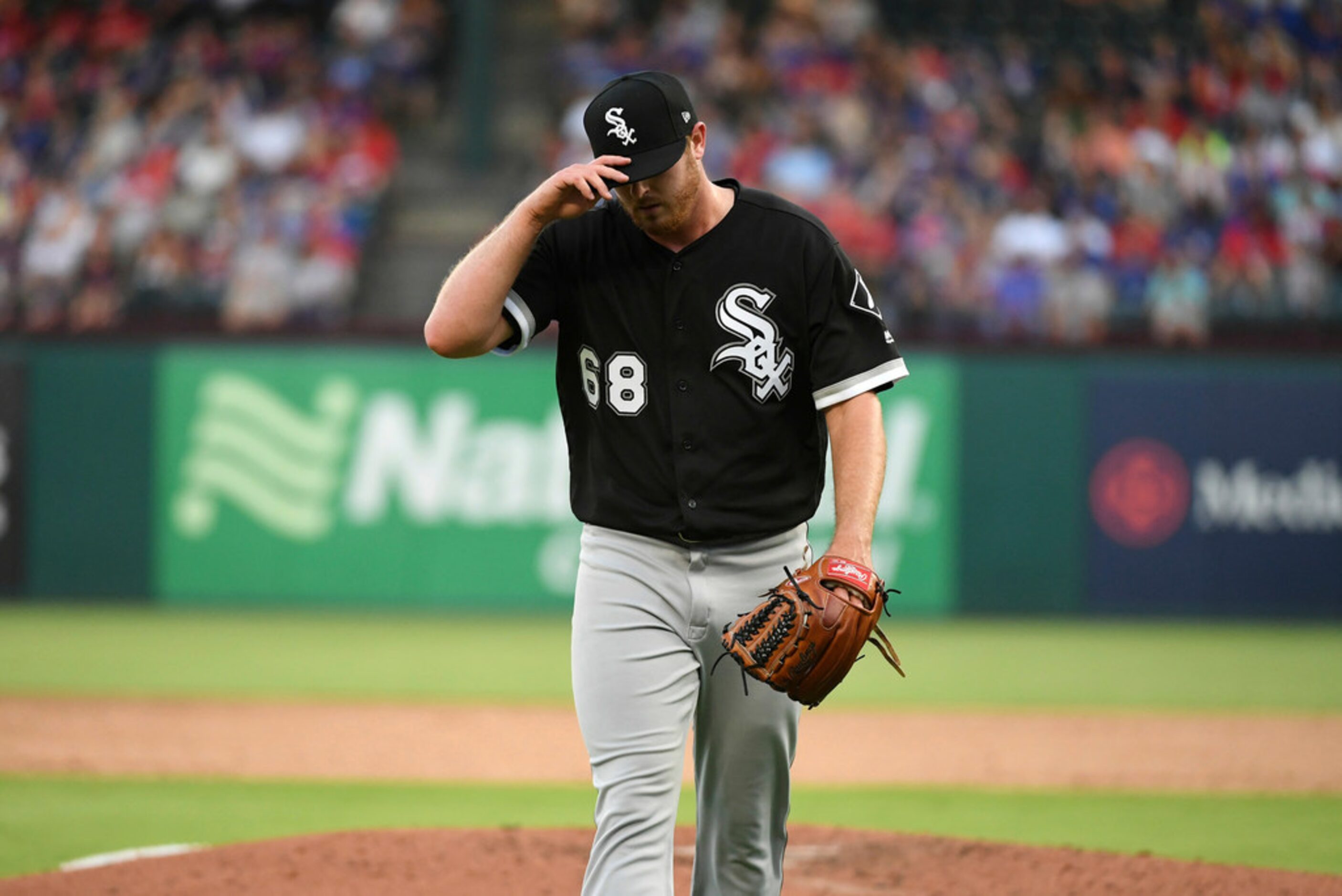 Chicago White Sox starting pitcher Dylan Covey walks off the field after giving up seven...