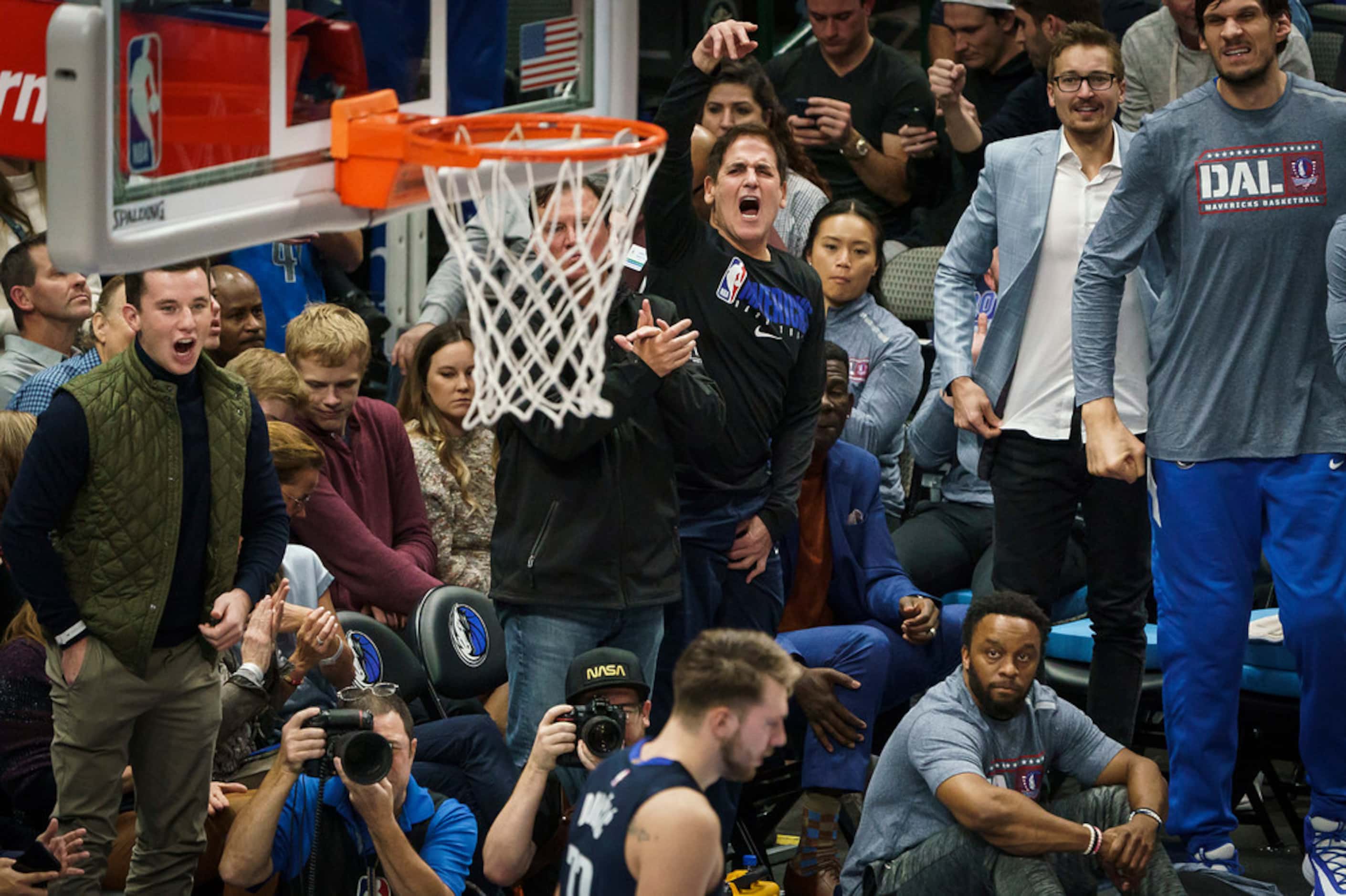 Dallas Mavericks owner Mark Cuban celebrates a basket by guard Luka Doncic (bottom) during...