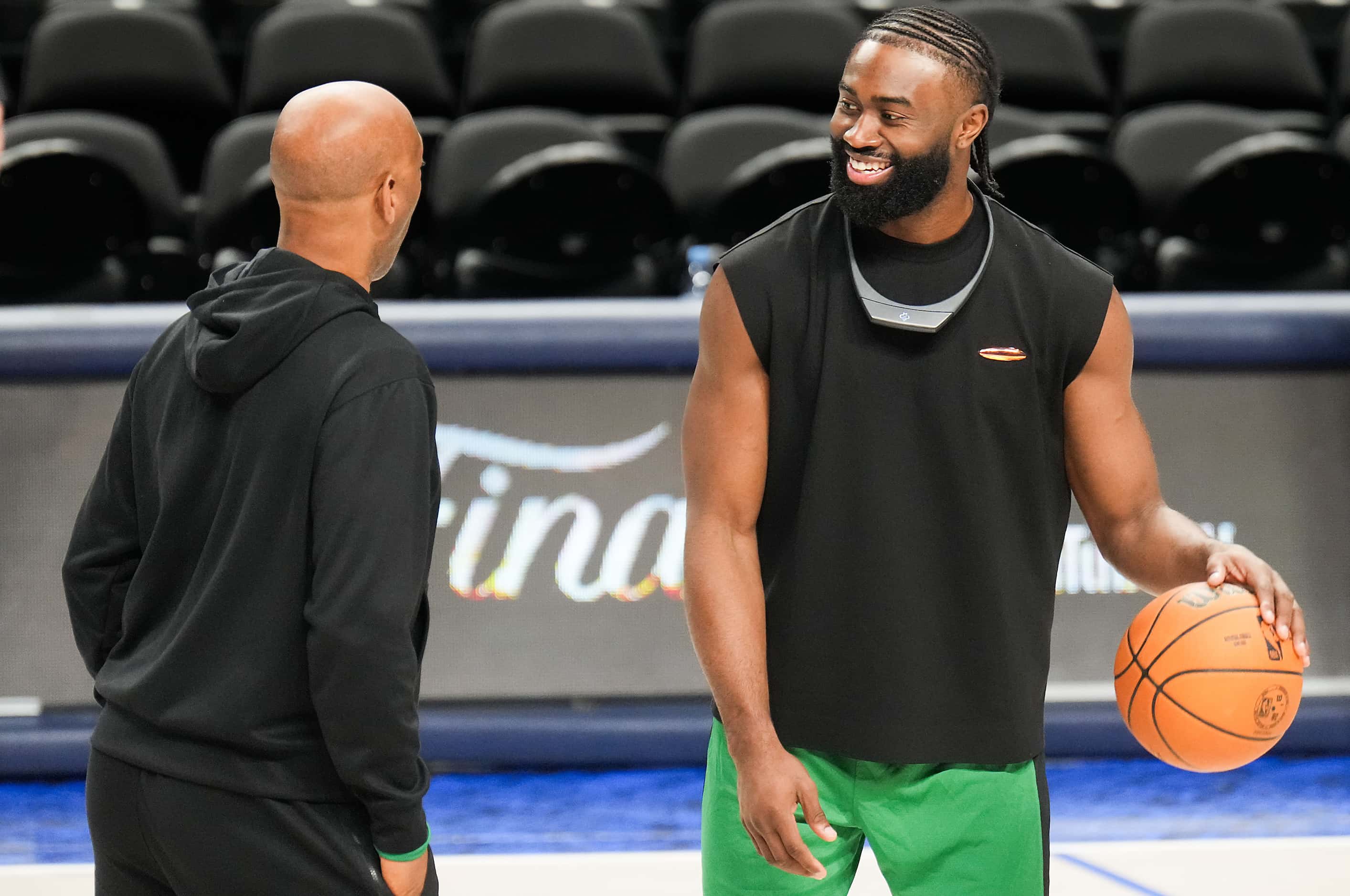 Boston Celtics guard Jaylen Brown laughs with assistant coach Sam Cassell during a team...