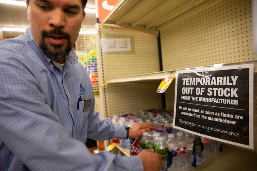 Shaun Paeth, head of general merchandise, refills the water aisle at Albertson's on March...