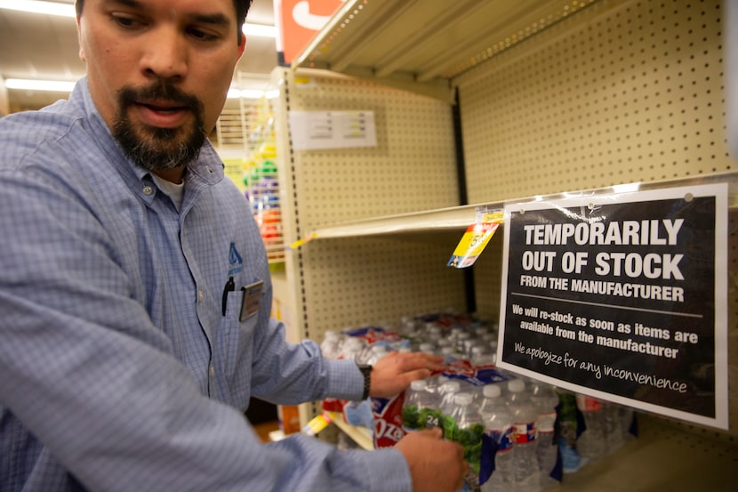 Shaun Paeth, head of general merchandise, refills the water aisle at Albertson's on March...