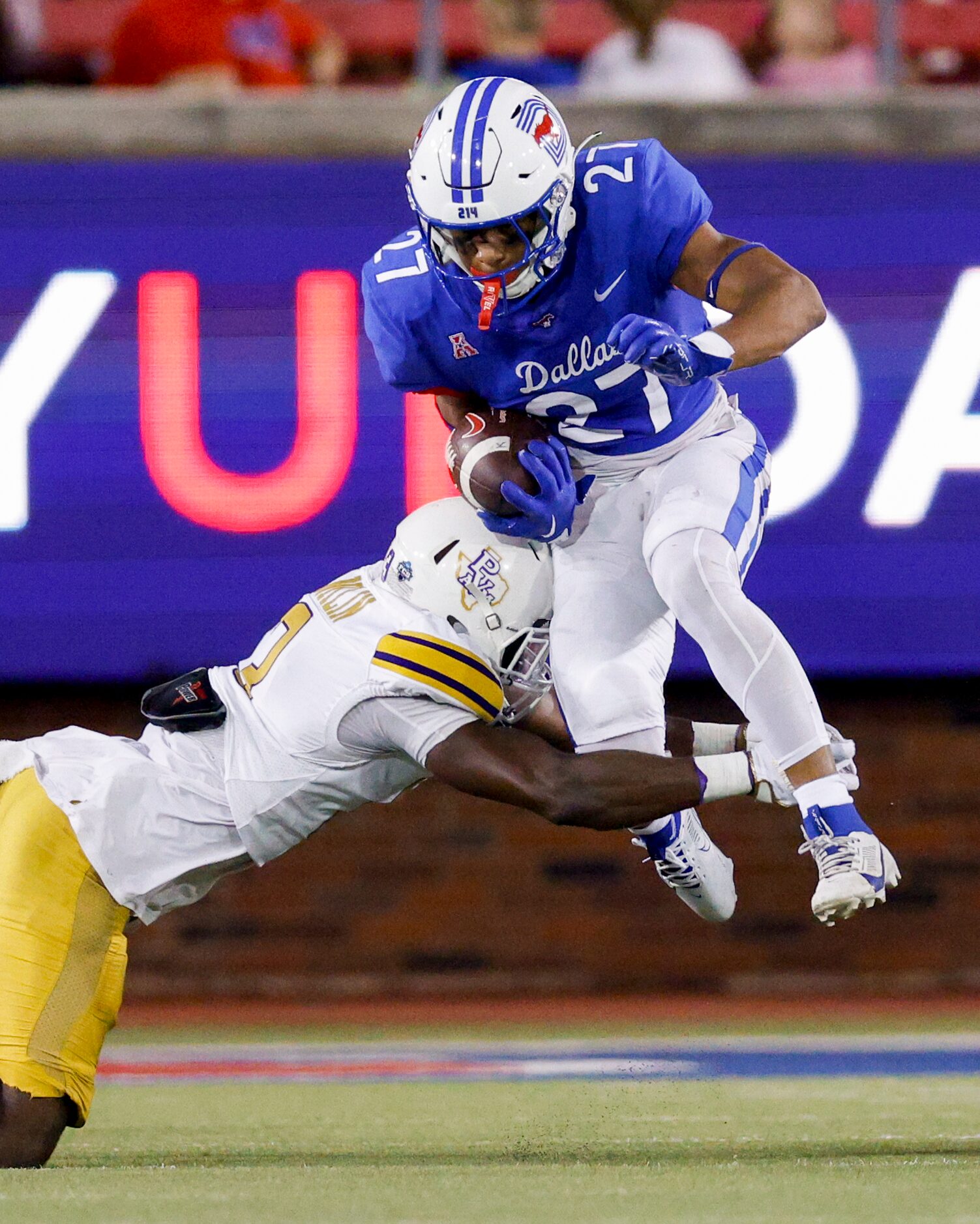 SMU running back Zane Minors (27) hurdles to avoid a tackle from Prairie View A&M defensive...