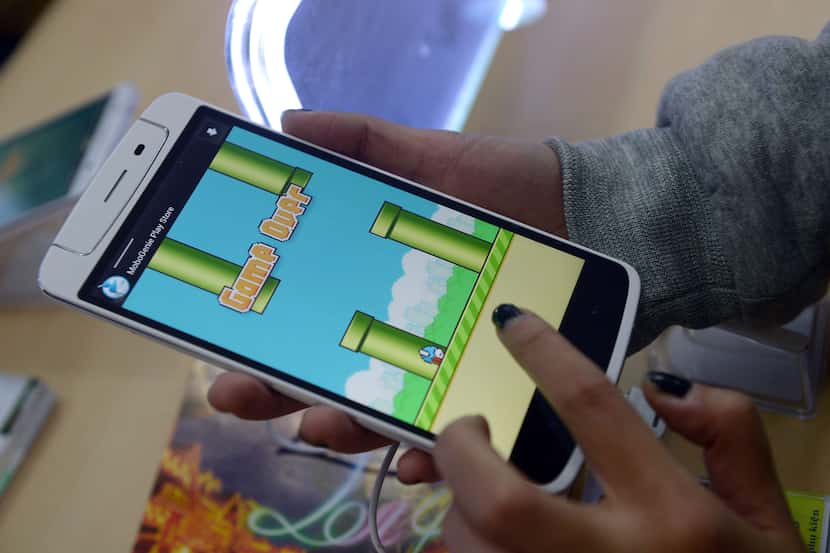 An employee plays the game Flappy Bird at a smartphone store in Hanoi on February 10, 2014. ...