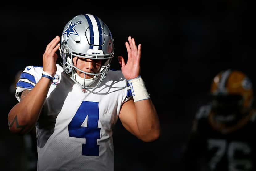 Dallas Cowboys quarterback Dak Prescott (4) listens for the next play before going to the...