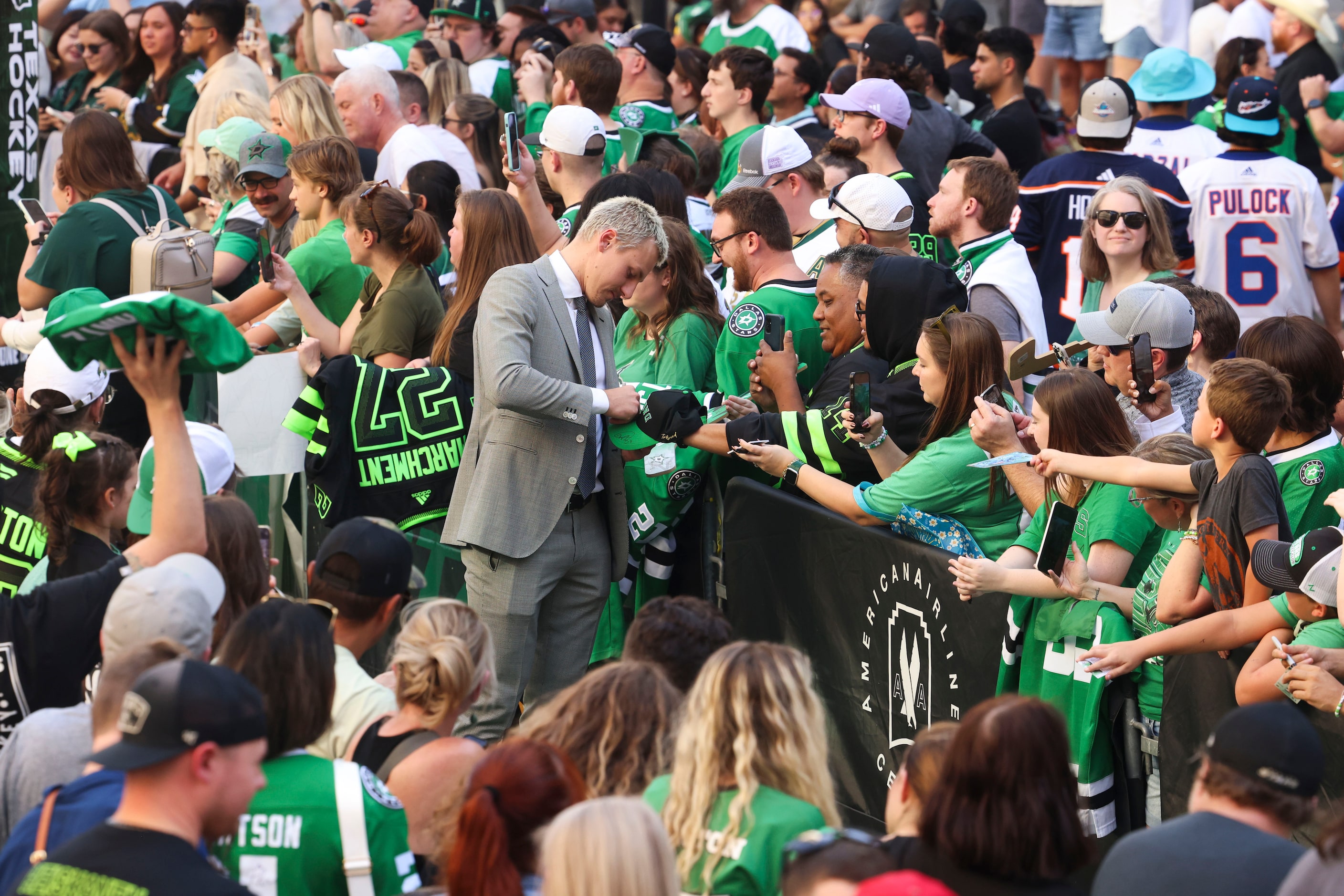 Dallas Stars center Roope Hintz gives autographs to fans as he makes his way during the...