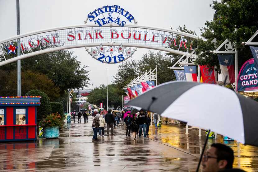 Fair attendees walk in the rain at the State Fair of Texas in Dallas on Oct. 17, 2018. The...