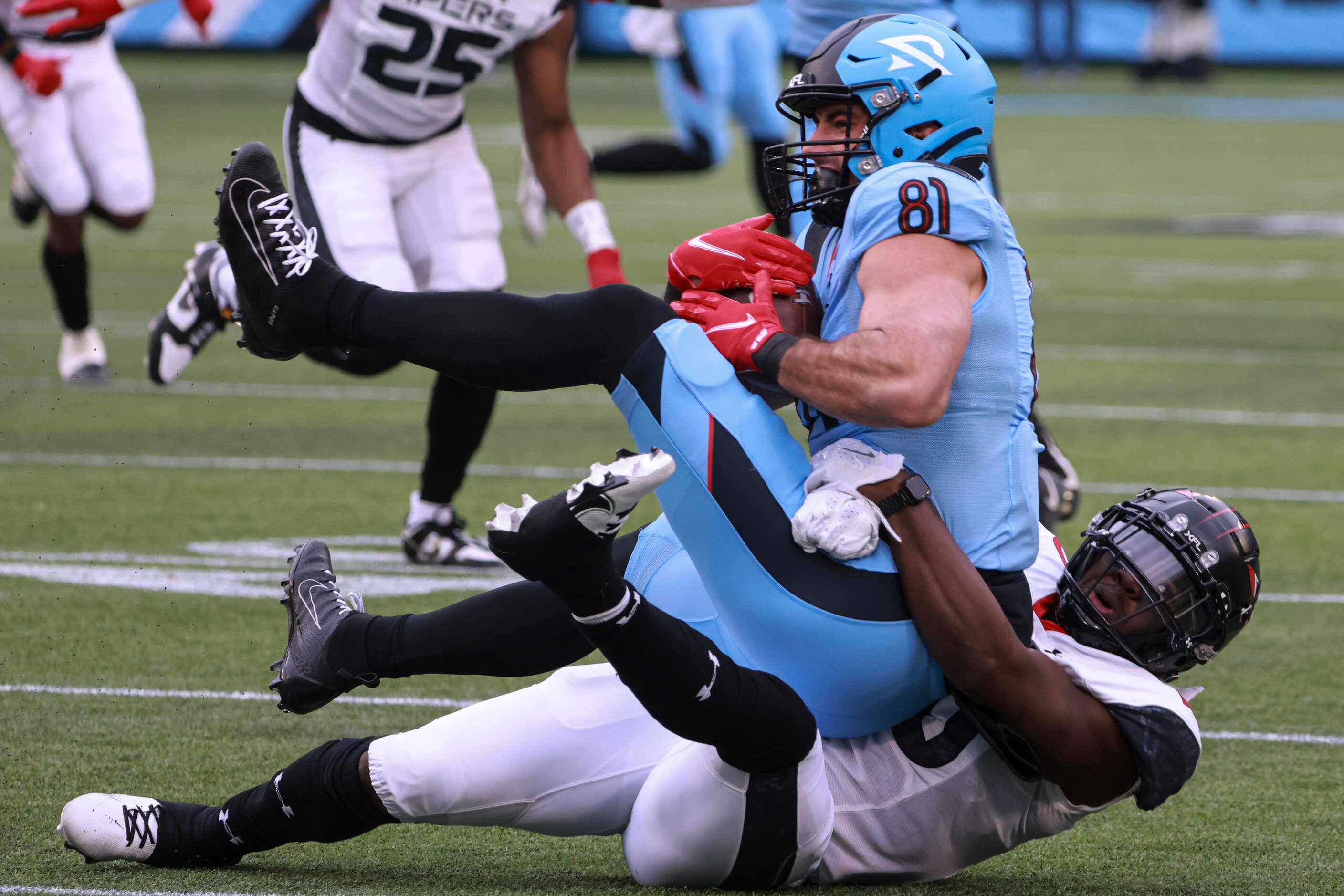 Arlington Renegades tight end Nate Becker (81) is tackled by Vegas Vipers linebacker Jawuan...