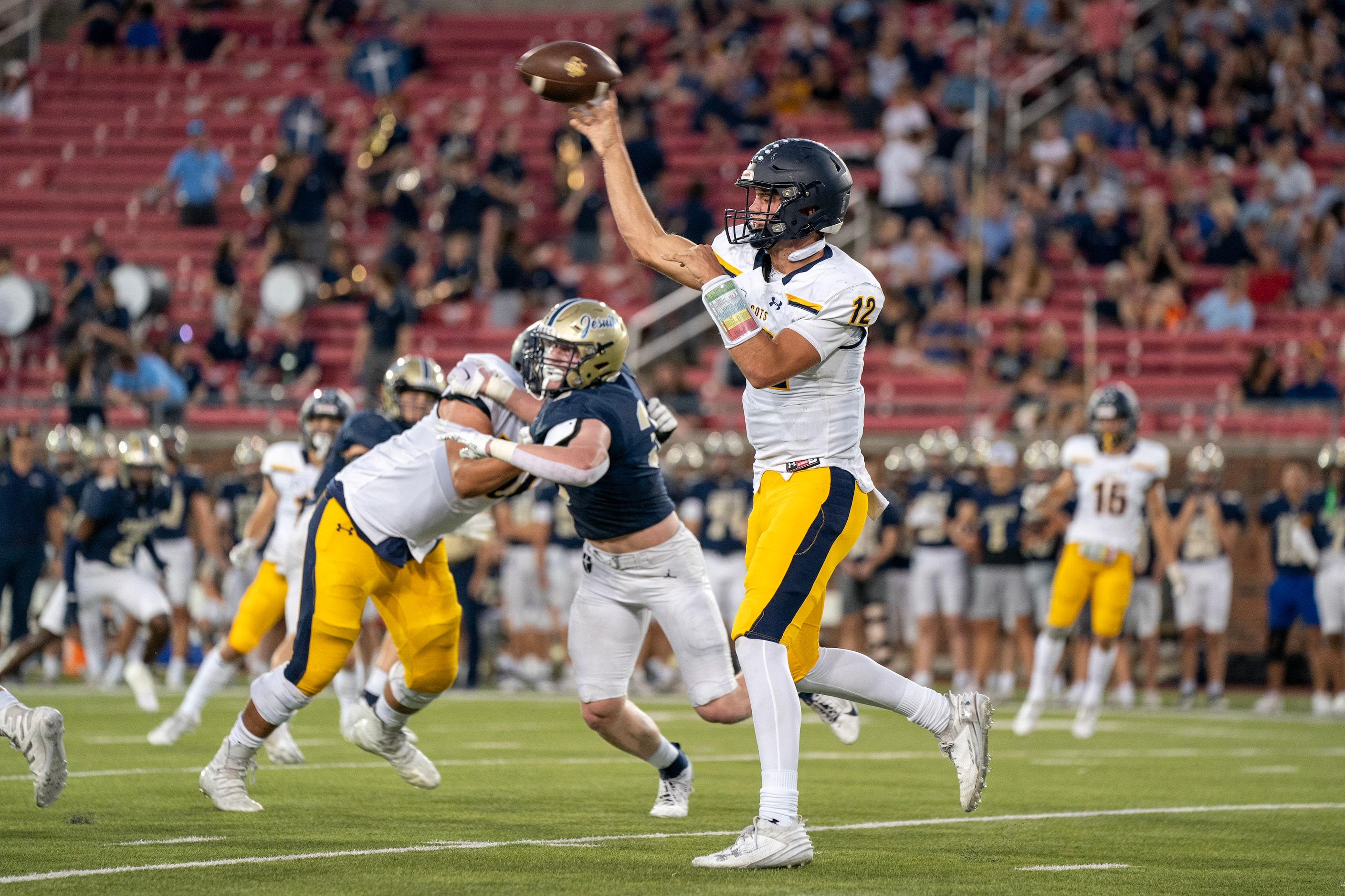 Highland Park senior quarterback Warren Peck (12) throws a pass against Jesuit during the...