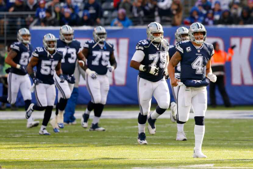 Dallas Cowboys quarterback Dak Prescott (4) leads his teammates onto the field before facing...