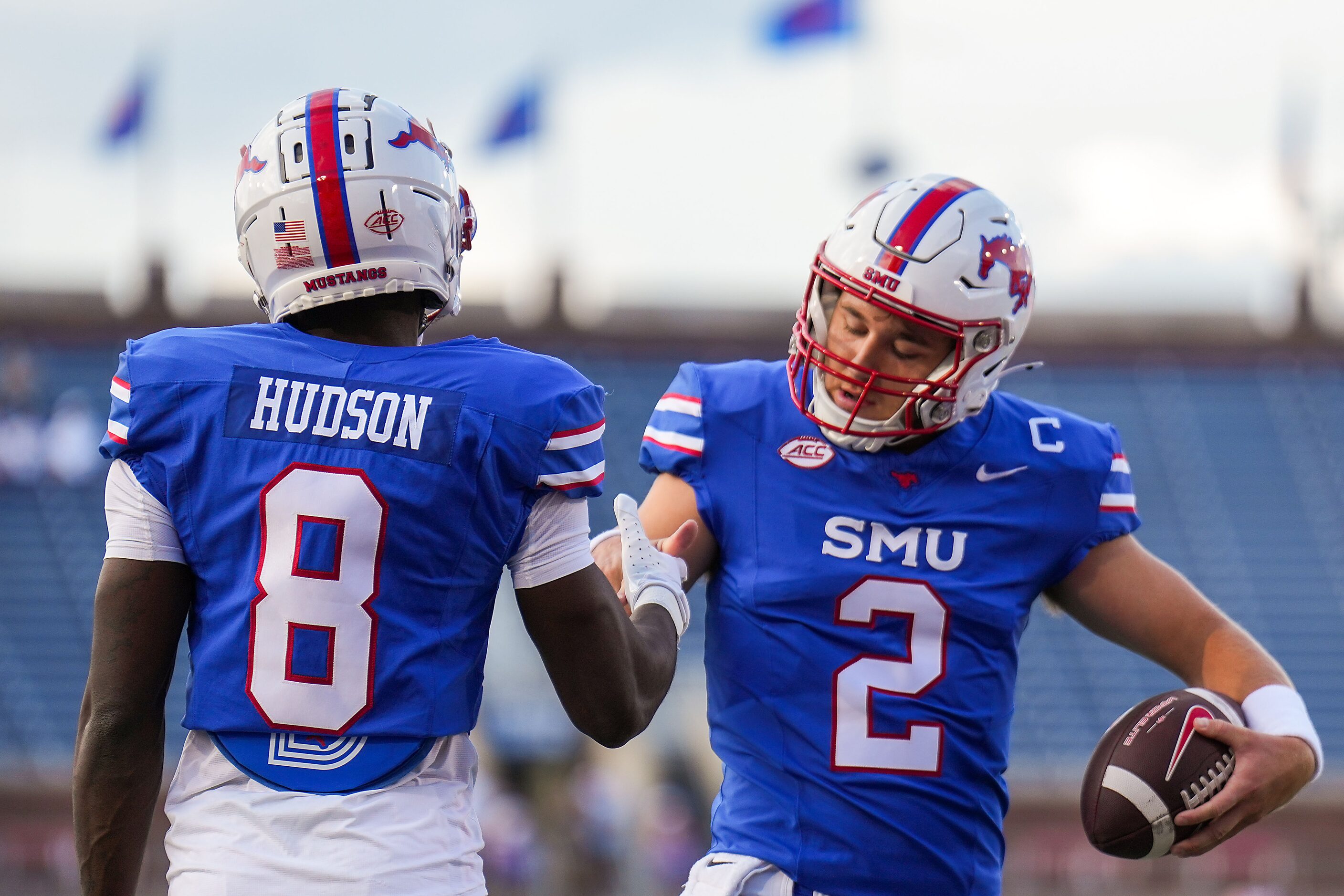 SMU quarterback Preston Stone shakes hands with wide receiver Jordan Hudson as they warm up...