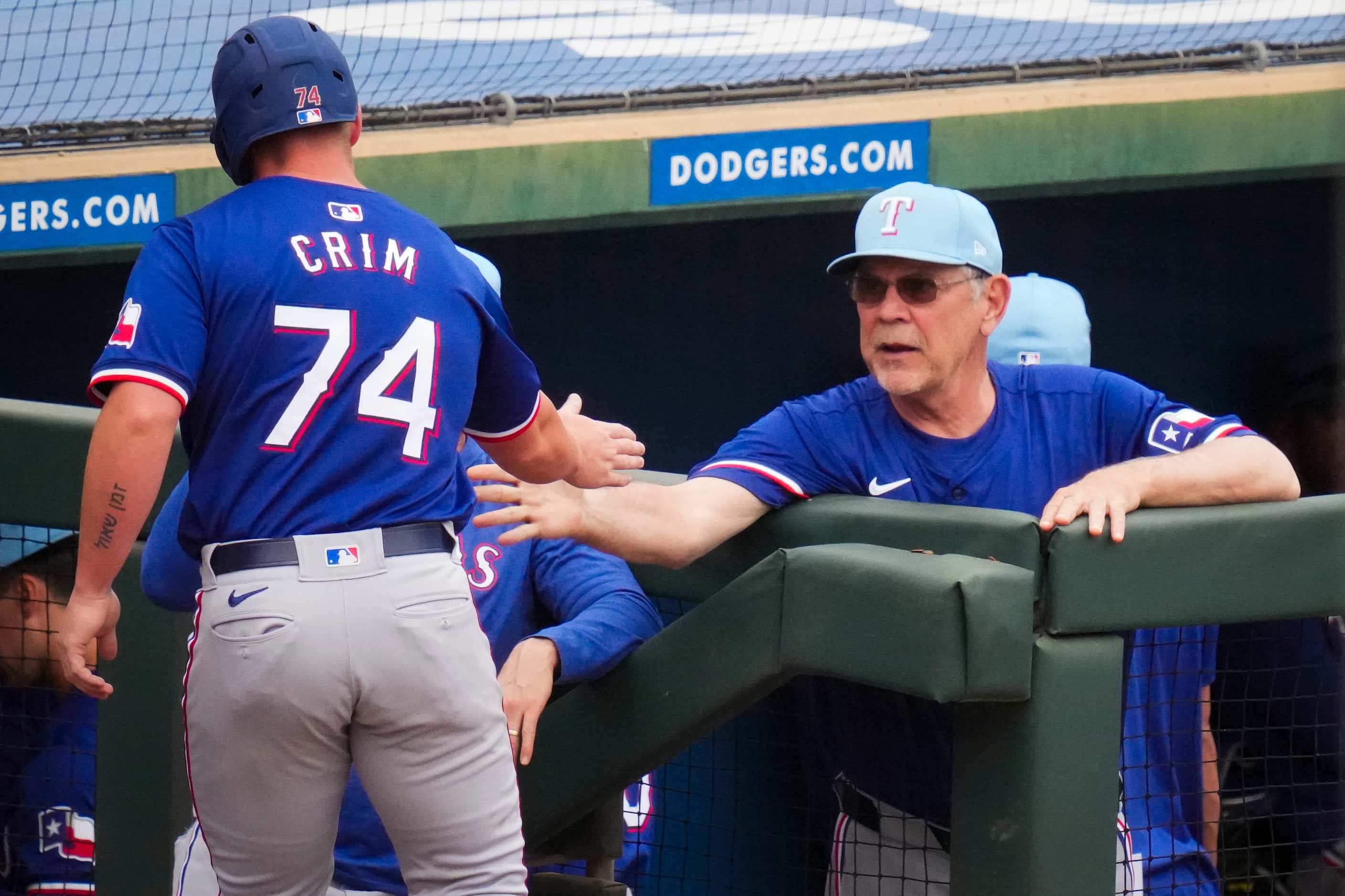 Texas Rangers designated hitter Blaine Crim gets a hand from manager Bruce Bochy after...
