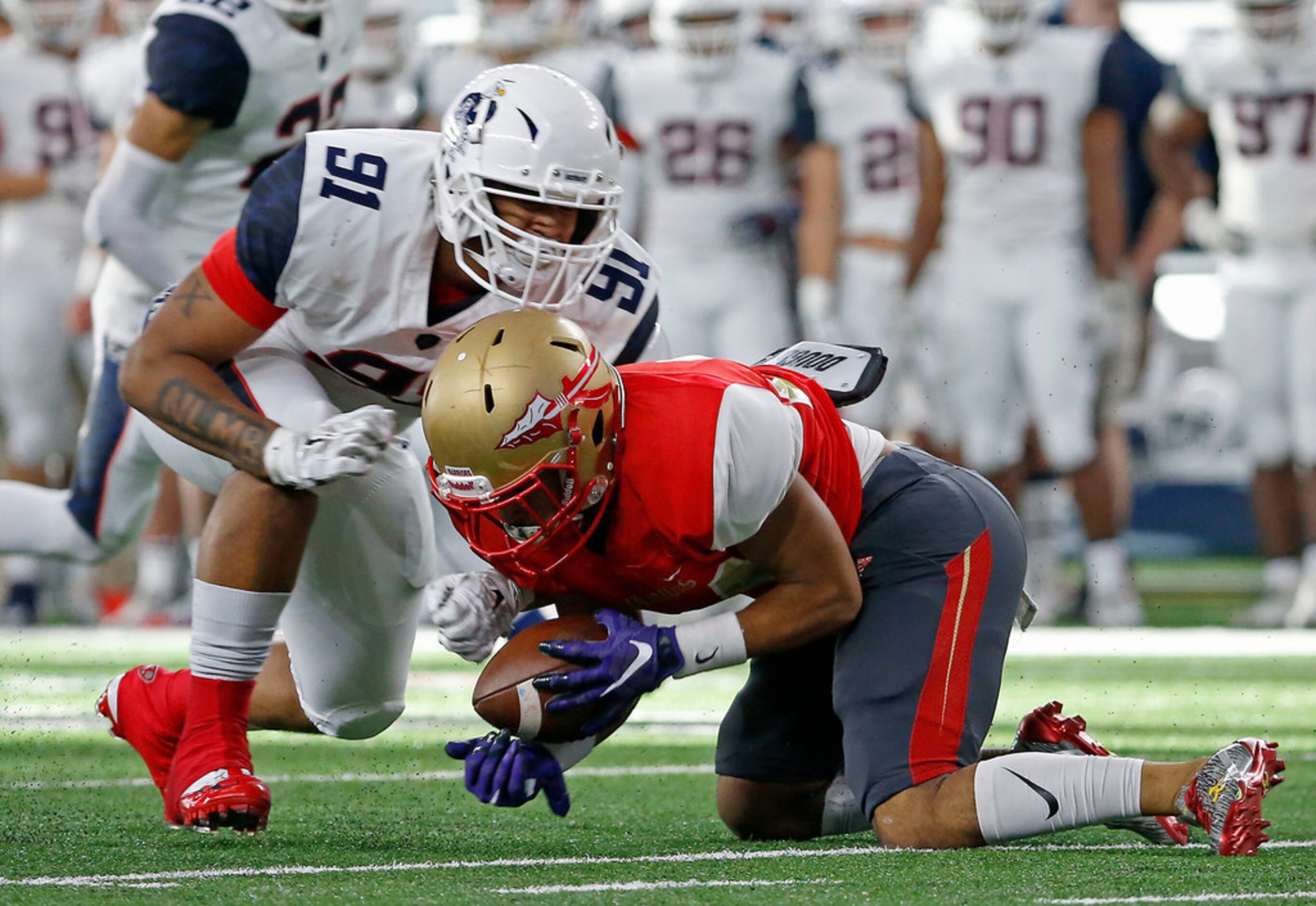 South Grand Prairie's Jachin Like (24) recovers his won fumble as he's tackled by Allen's...