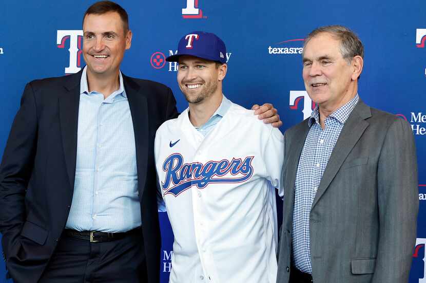 New Texas Rangers starting pitcher Jacob deGrom (center) poses for photos with new manger...