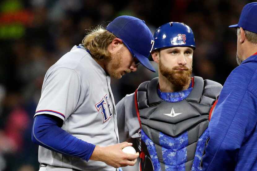 Texas Rangers starting pitcher A.J. Griffin, left, talks with catcher Jonathan Lucroy and...