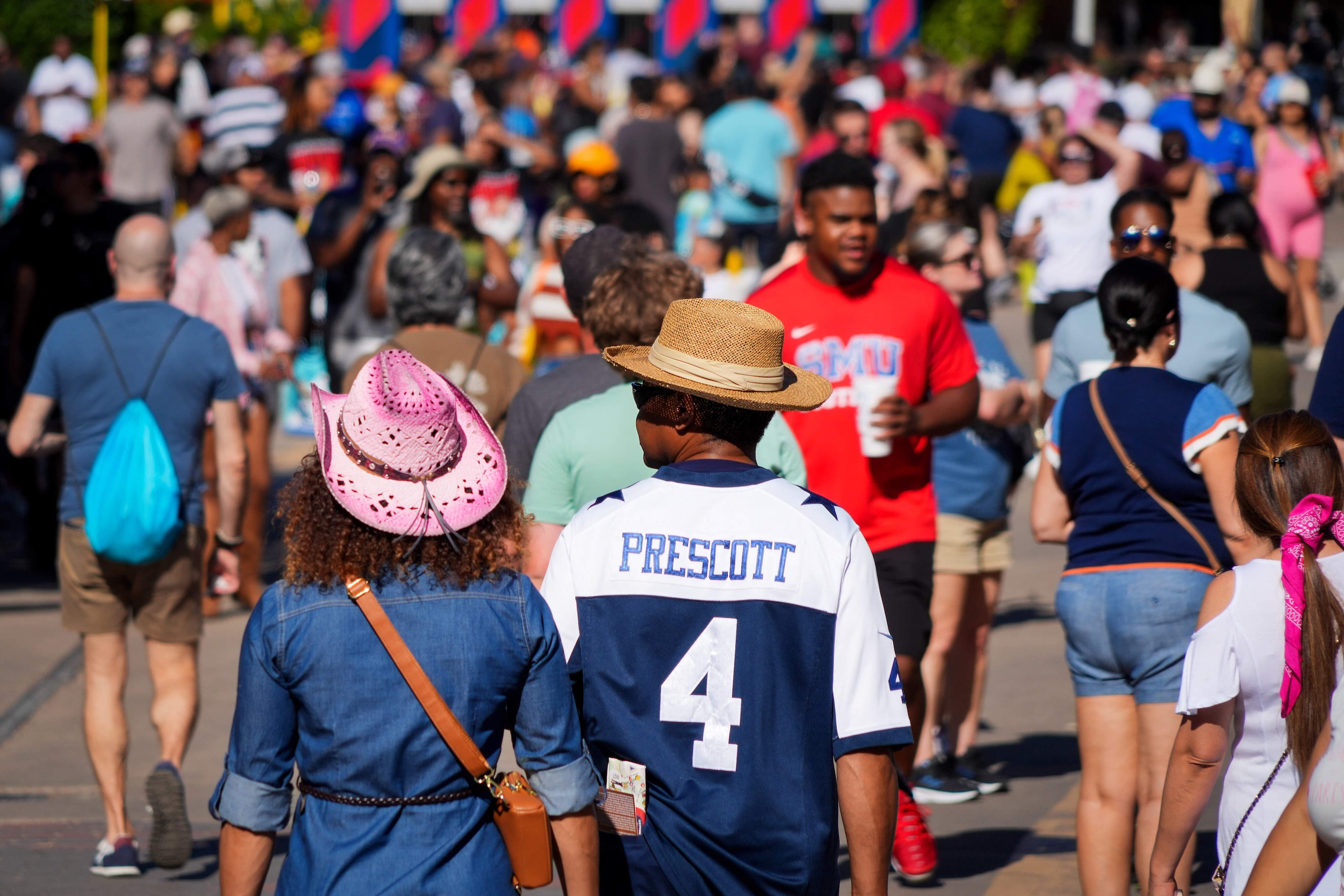 Fairgoers walk along Grand Avenue at the State Fair of Texas on Sunday, Sept. 29, 2024, in...