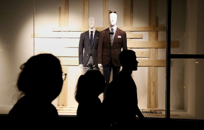 Protesters march by mannequins in storefronts along Main Street during a protest held by the...