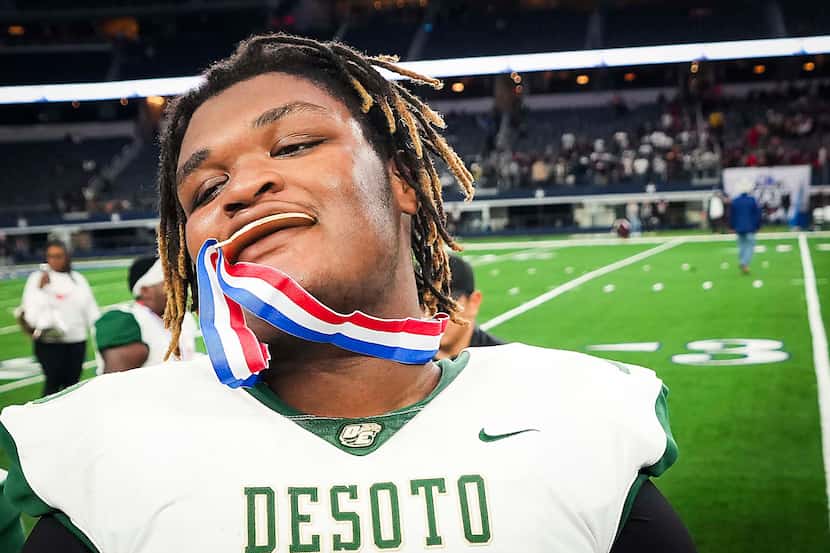 DeSoto offensive lineman David Russell bites his championship medal after a victory over...