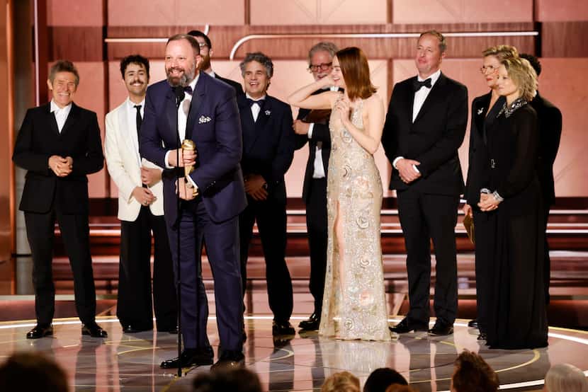 Filmmaker Yorgos Lanthimos, foreground, with the cast as he accepts the award for best...