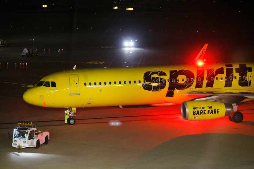 Grounds crew workers ready a Spirit Airlines jet for takeoff at Dallas-Fort Worth...