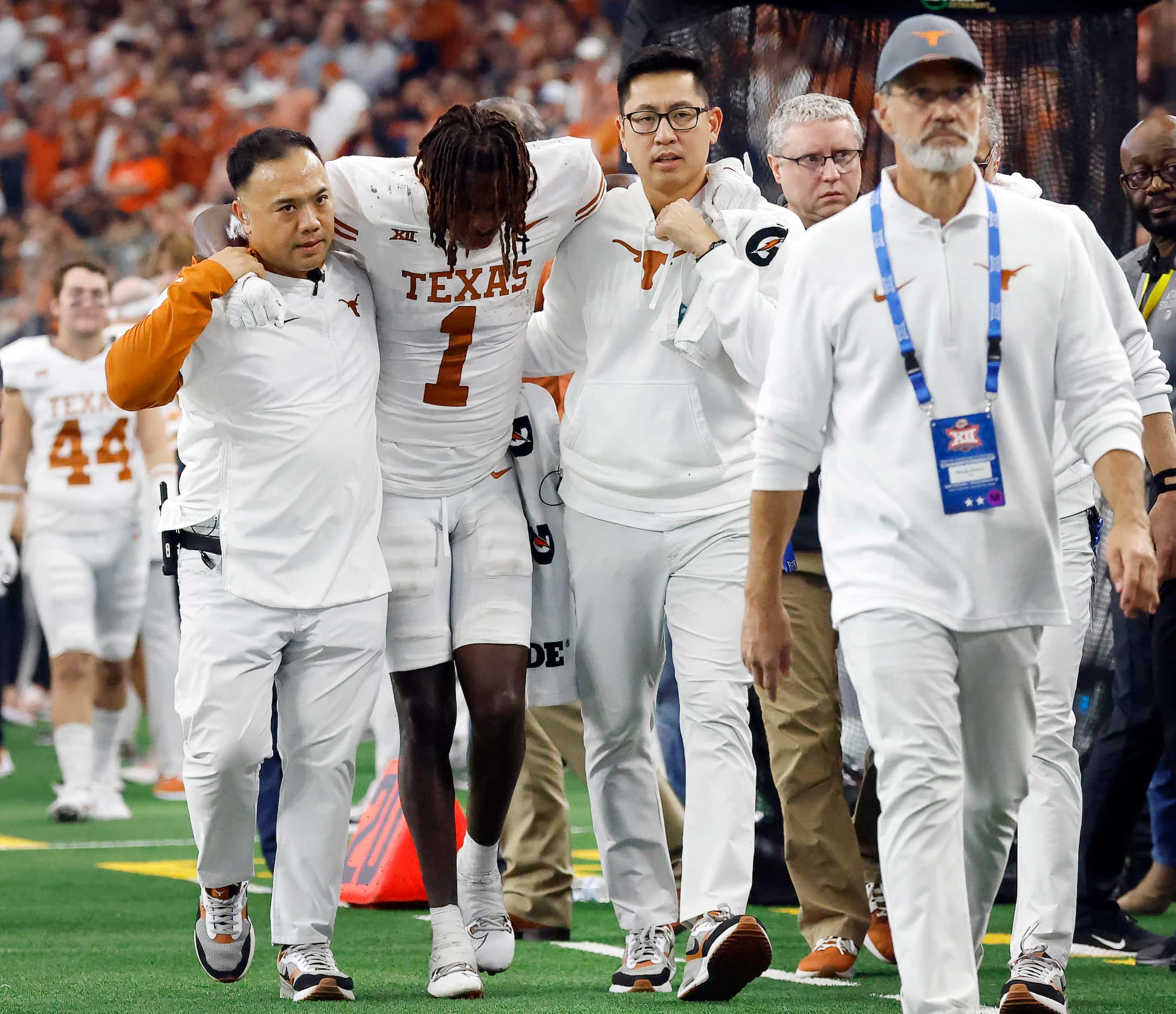 Texas Longhorns wide receiver Xavier Worthy (1) is helped to the locker room by trainers...