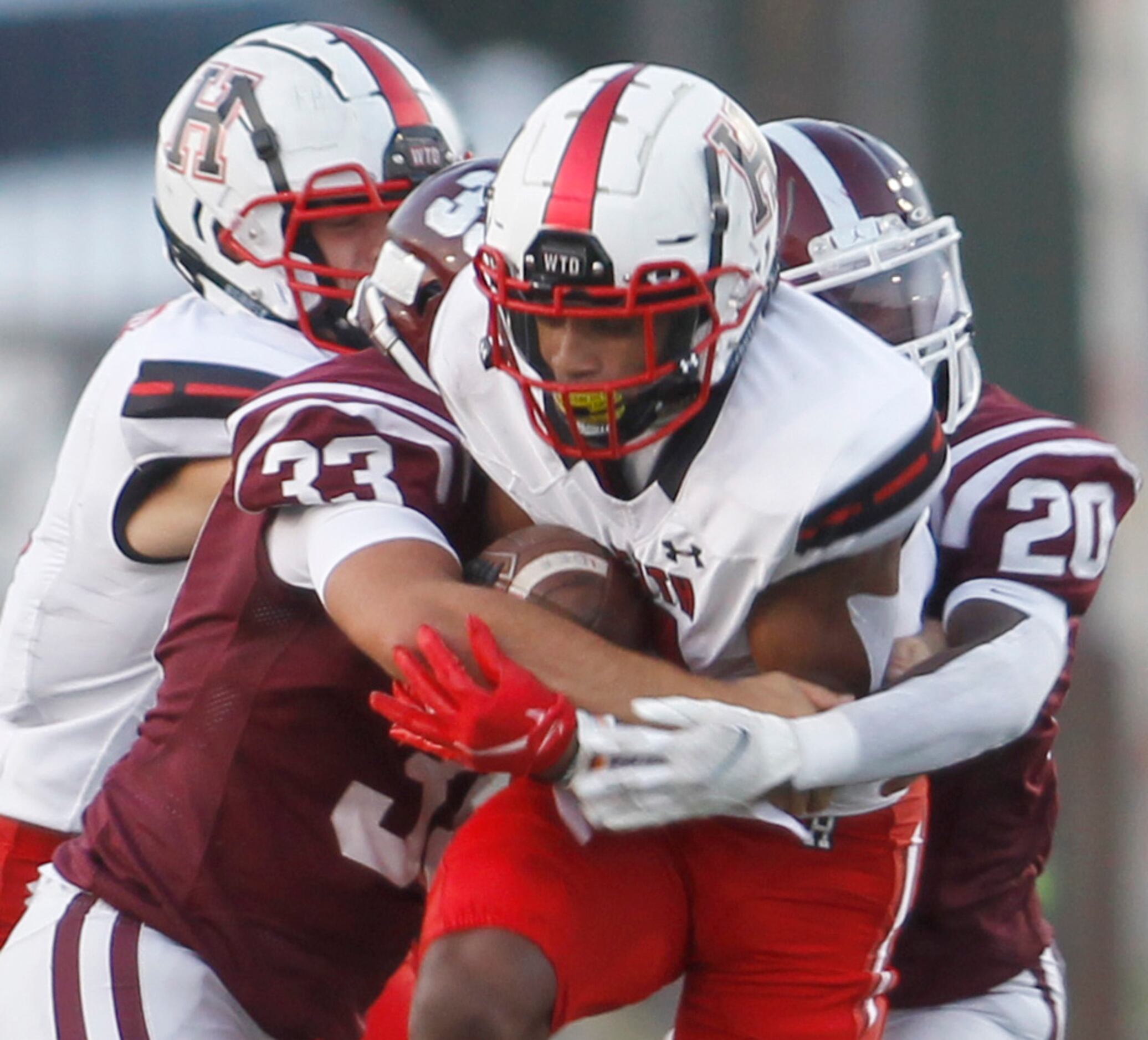 Rockwall Heath receiver Jay Fair (1) is stopped by Red Oak defenders Zach Allen (33) and...